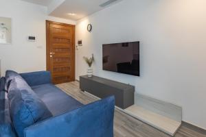 sala de estar con sofá azul y TV de pantalla plana en Luxury property in Gzira just minutes away from the seafront and Restaurants, en Il-Gżira