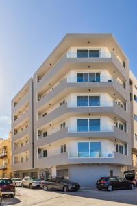 an apartment building with cars parked in front of it at Luxury property in Gzira just minutes away from the seafront and Restaurants in Il-Gżira
