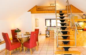 ein Wohnzimmer mit einem Tisch und Stühlen sowie einer Wendeltreppe in der Unterkunft VILLA LILIA - das charmante Ferienhaus am See in Potsdam in Potsdam