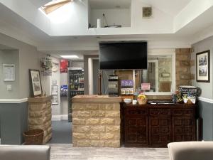 a store with a flat screen tv above a counter at Mansfield Lodge Hotel Ltd in Mansfield