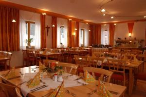 una sala da pranzo con tavoli e sedie in legno di Witikohof a Haidmühle
