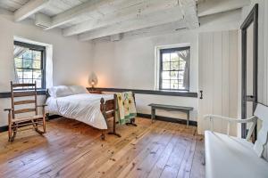 a bedroom with a bed and a table and two windows at Historical Thurmont Escape with Furnished Deck! in Thurmont
