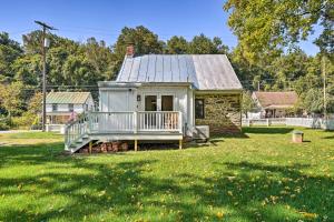 a small house with a porch on a grass field at Historical Thurmont Escape with Furnished Deck! in Thurmont