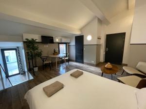 a room with a white bed and a living room at Casa Hotel in Aix-en-Provence