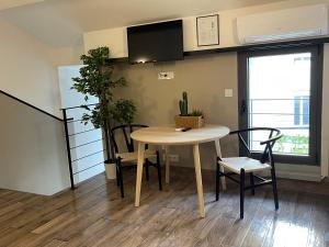 - une salle à manger avec une table, des chaises et une télévision dans l'établissement Casa Hotel, à Aix-en-Provence