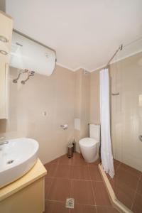 a bathroom with a white sink and a toilet at Moana Lighthouse Apartment in Ahtopol