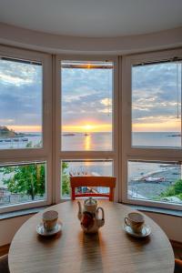 uma sala de jantar com uma mesa com duas chávenas de chá em Moana Lighthouse Apartment em Ahtopol