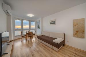 a living room with a couch and a table at Moana Lighthouse Apartment in Ahtopol