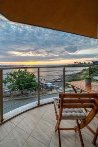 a table and chair on a balcony with a view of the ocean at Moana Lighthouse Apartment in Ahtopol