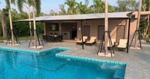 a house with a swimming pool next to a building at I love phants Lodge in Ban Huai Thawai