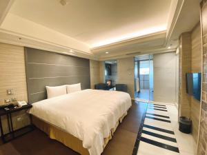 a bedroom with a large bed and a television at Burgary Hotel in Taipei