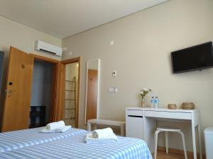 a room with two beds and a tv on the wall at Green & Sea Comporta Retreat in Comporta
