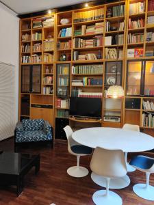 a room with a table and chairs and bookshelves at residenza San Martino in Naples