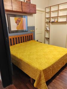 um quarto com uma cama com uma colcha amarela em residenza San Martino em Nápoles