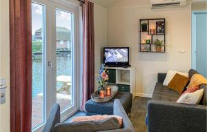 a living room with a couch and a sliding glass door at Lovely Home In Breukelen With House Sea View in Breukelen