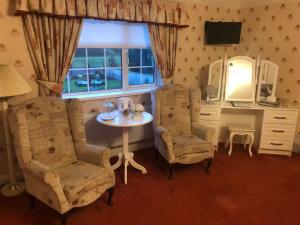 un soggiorno con tavolo, due sedie e finestra di Meadowside B&B a Bunclody