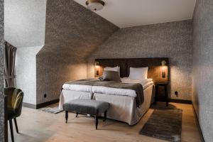 a bedroom with a large bed and a chair at Skara Stadshotell in Skara