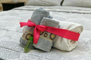 un mucchio di asciugamani su un letto con un nastro rosso di B&B a Capua - I PORTICI del centro a Capua