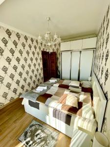 1 dormitorio con cama y lámpara de araña en Central City en Kutaisi