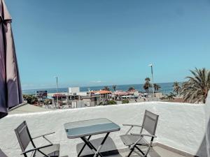 una mesa y 2 sillas en un balcón con vistas a la playa en Studios CC Victoria Ocean View, en Playa de las Américas