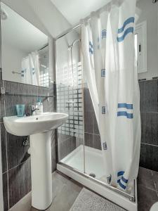 a bathroom with a shower curtain and a sink at Studios CC Victoria Ocean View in Playa de las Americas