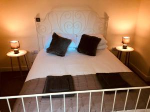 a large white bed with two lamps on both sides at Cardiff City centre Apartment lifestyle!! in Cardiff