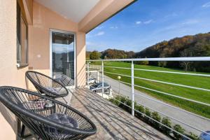 a balcony with two chairs and a view of a field at Holiday Home Hanna Toplice Sveti Martin in Sveti Martin na Muri