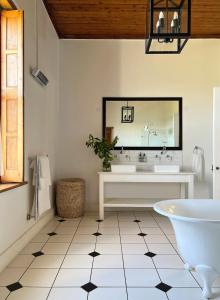 a bathroom with a tub and a sink and a mirror at Penhill Farm Manor House in Nuy