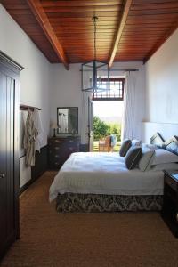 Un dormitorio con una cama grande con techo de madera. en Penhill Farm The Manor House, en Nuy