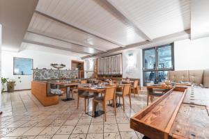 a restaurant with wooden tables and chairs and windows at Albergo Caffe Centrale in Mezzocorona