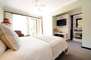 a bedroom with a white bed and a large window at Beachwalk Bed and Breakfast - #Solar Energy #No Loadshedding in Port Elizabeth