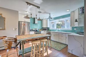 een keuken met een houten tafel en barkrukken bij Vibrant Milford Home with Boat Dock and Patio! in Milford