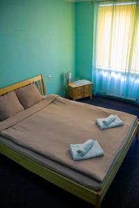 a bedroom with a large bed with two towels on it at Olimpija Hotel & SPA in Daugavpils