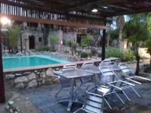 uma mesa e cadeiras ao lado de uma piscina em Nkisi Guesthouse em Kang