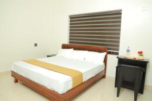 a bedroom with a bed and a black table at Athirappilly Ambady Resort in Athirappilly