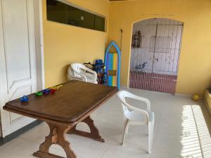 uma sala de jantar com uma mesa de madeira e cadeiras brancas em Casa de praia no Ariramba, Mosqueiro, Belém/PA. em Belém