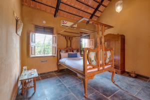 a bedroom with a canopy bed in a room at CosmicStays Rustic Elegance - Traditional Wada Inspired Living in Shirwal