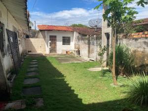 a yard with a house and a fence at Casa de praia no Ariramba, Mosqueiro, Belém/PA. in Belém