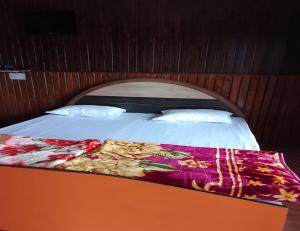 a bed in a room with an orange and white bedvisor at Aangan Resort, Bageshwar in Bāgeshwar