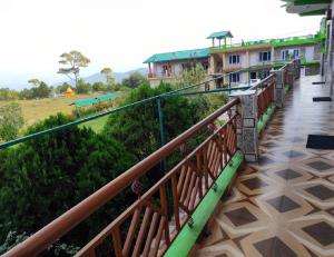 a wooden walkway with a building in the background at Aangan Resort, Bageshwar in Bāgeshwar