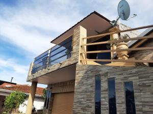 ein Haus mit einem Balkon an der Seite in der Unterkunft Hospedaje Margarita in Encarnación