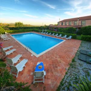 a swimming pool with chaise lounge chairs at Agriturismo Biologico Corte Aragonese in Santa Maria di Licodia