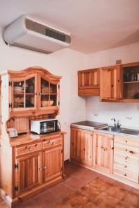 uma cozinha com armários de madeira e um lavatório em Appartamento a Campo Felice - Treeffe em Collimento
