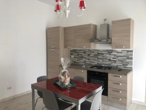 a kitchen with a red table and a stove at Casa Vacanze De Nittis - Meridia Collection in Barletta