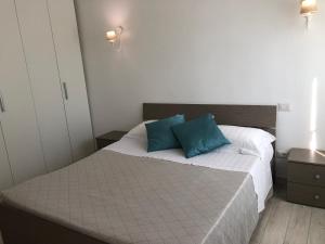 a bedroom with a bed with two blue pillows on it at Casa Vacanze De Nittis - Meridia Collection in Barletta