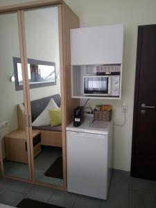 a small kitchen with a microwave and a couch at Cafe und Pension Ringer in Vilseck