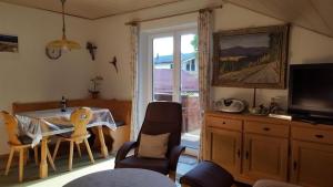 a living room with a table and chairs and a television at Ferienwohnung Heimbeck Kochel in Kochel