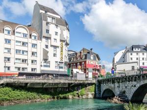 un pont sur une rivière dans une ville avec des bâtiments dans l'établissement Hôtel Agena, à Lourdes