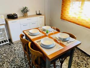 una mesa de comedor con platos y copas de vino en Casa Rural Las Peñetas, en Bolbaite
