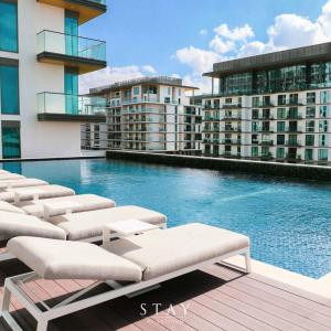 a swimming pool with chaise lounges next to some buildings at STAY BY LATINEM Luxury Studio Holiday Home G6-6711 near Burj Khalifa in Dubai